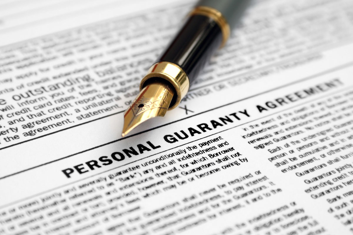 close up of personal guaranty agreement with pen pointing to signature line