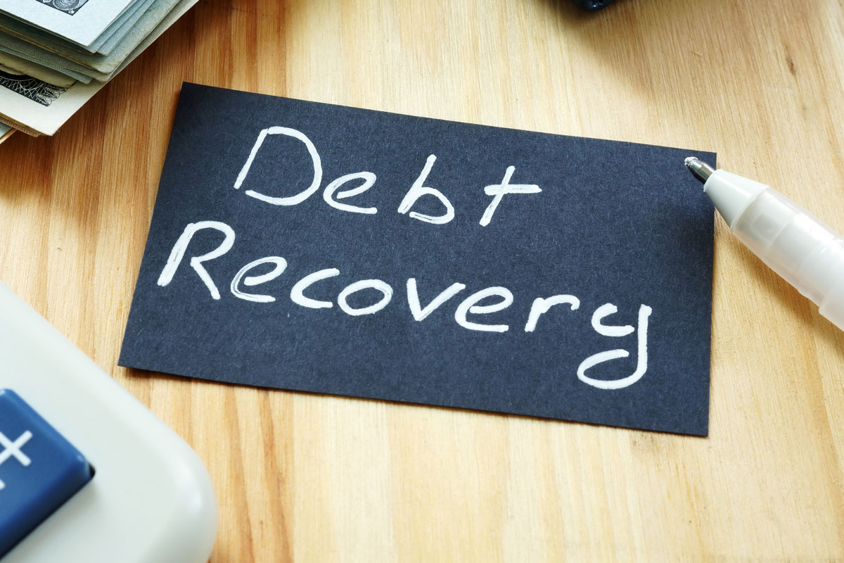 The words: Debt Recovery written on a black card